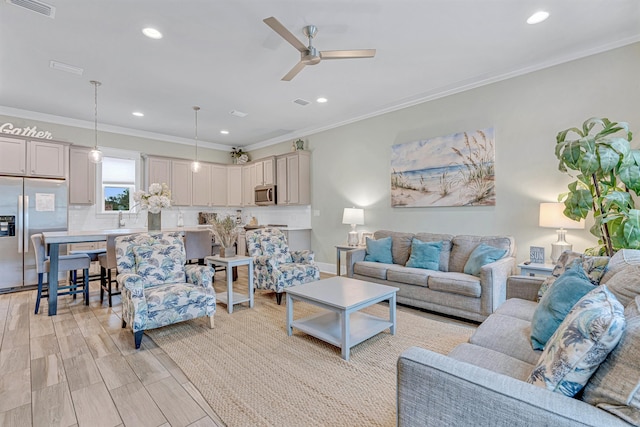 living room with ceiling fan, ornamental molding, recessed lighting, and light wood-style flooring