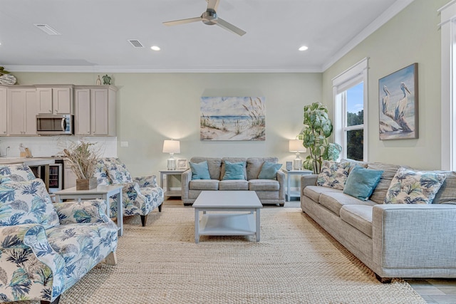 living room with crown molding, ceiling fan, recessed lighting, and light wood-style flooring