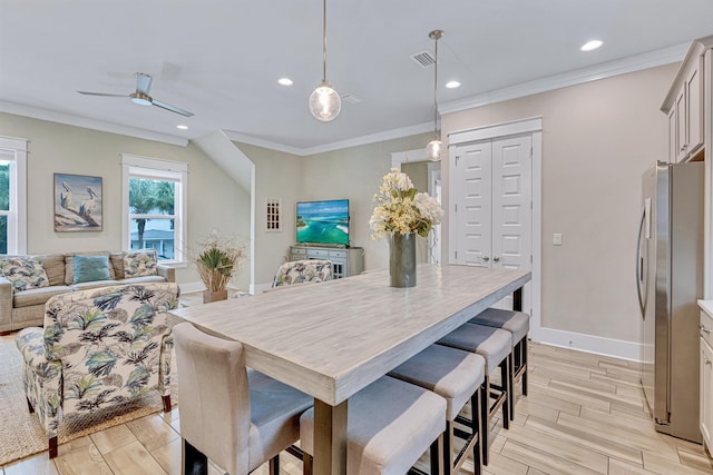 dining area with light wood-style flooring, recessed lighting, a ceiling fan, crown molding, and baseboards