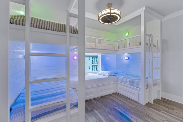 bedroom featuring wood finished floors, baseboards, and crown molding
