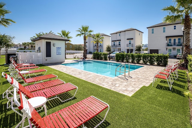 community pool with a patio area and a residential view