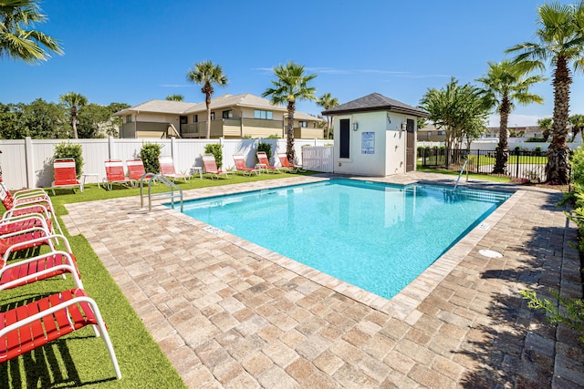 community pool with a patio and fence