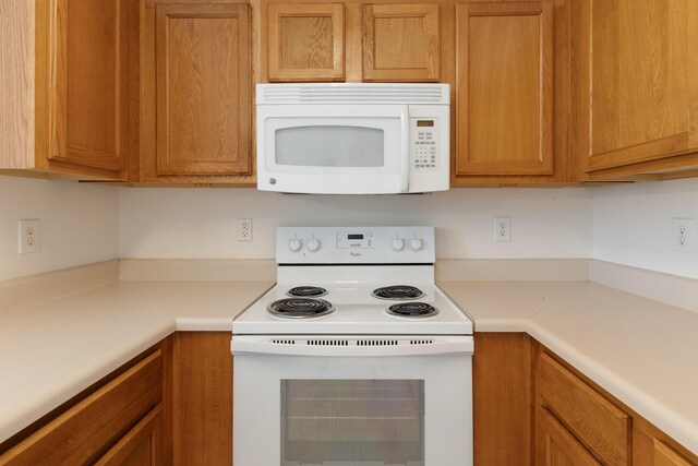 282 Swaying Pine Ct, Crestview, FL 32539 - kitchen featuring white appliances, light countertops, and brown cabinets