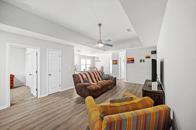 3163 Haskell Langley Rd, Crestview, FL 32539 - living area with light wood-type flooring, ceiling fan, baseboards, and a tray ceiling