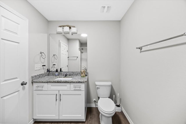 3163 Haskell Langley Rd, Crestview, FL 32539 - bathroom featuring wood finished floors, toilet, vanity, and baseboards