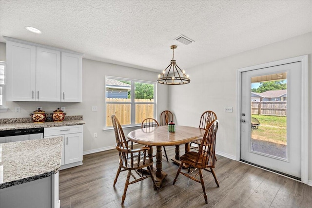 3163 Haskell Langley Rd, Crestview, FL 32539 - dining room with wood finished floors, a chandelier, baseboards, and a textured ceiling