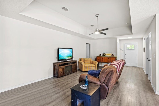 3163 Haskell Langley Rd, Crestview, FL 32539 - living area featuring wood finished floors, baseboards, ceiling fan, and a raised ceiling