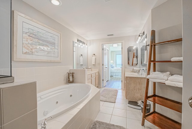 8601 Surf Dr Unit 2W, Panama City Beach, FL 32408 - bathroom with connected bathroom, a tub with jets, vanity, and tile patterned floors