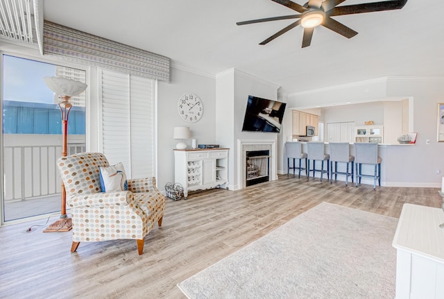 8601 Surf Dr Unit 2W, Panama City Beach, FL 32408 - living area featuring a ceiling fan, crown molding, wood finished floors, a fireplace, and baseboards