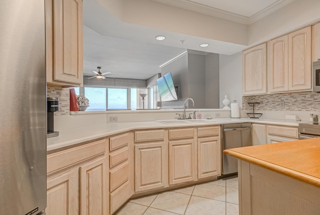 8601 Surf Dr Unit 2W, Panama City Beach, FL 32408 - kitchen featuring light brown cabinetry, stainless steel appliances, crown molding, a sink, and decorative backsplash