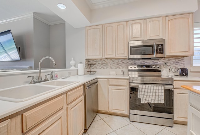 8601 Surf Dr Unit 2W, Panama City Beach, FL 32408 - kitchen featuring appliances with stainless steel finishes, light brown cabinetry, a sink, ornamental molding, and backsplash