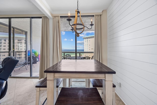 1096 Scenic Gulf Dr Unit 606, Miramar Beach, FL 32550 - tiled dining room with a chandelier, wood walls, crown molding, a water view, and a wall of windows