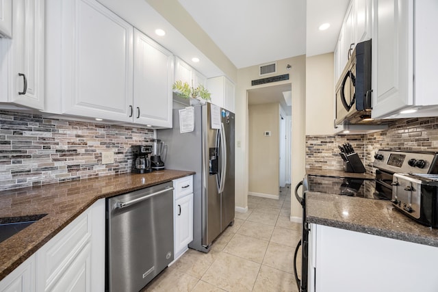 1096 Scenic Gulf Dr Unit 606, Miramar Beach, FL 32550 - kitchen featuring appliances with stainless steel finishes, white cabinets, light tile patterned floors, tasteful backsplash, and dark stone countertops