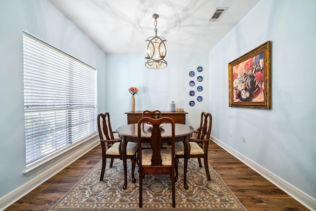 dining area featuring a chandelier, baseboards, and dark wood-type flooring