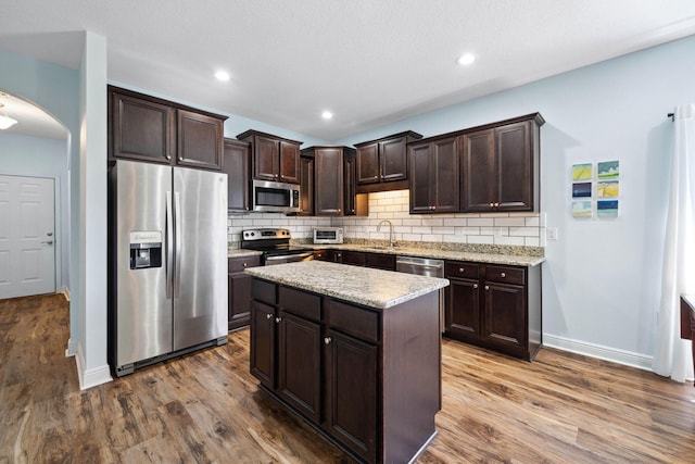 kitchen featuring appliances with stainless steel finishes, dark brown cabinets, tasteful backsplash, and recessed lighting
