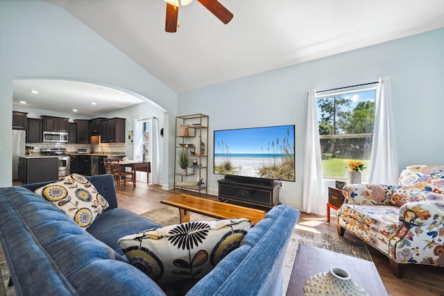 living room with arched walkways, a ceiling fan, wood finished floors, lofted ceiling, and recessed lighting