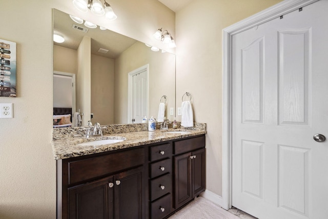 full bath featuring double vanity and baseboards