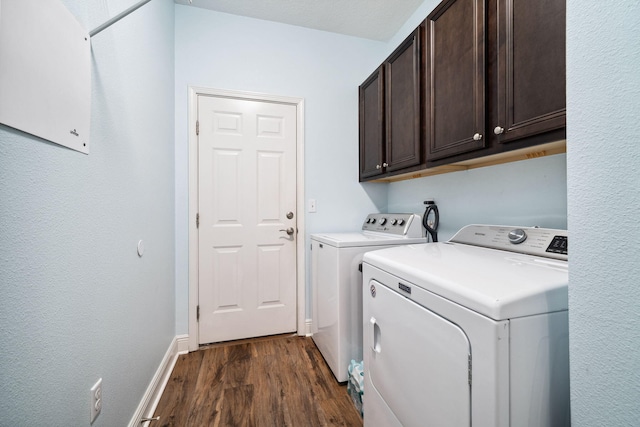 laundry area featuring washer and dryer, dark wood-type flooring, cabinet space, and baseboards