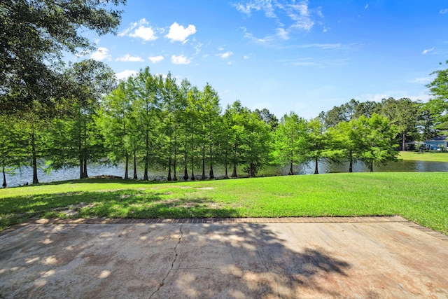 view of green lawn with a water view
