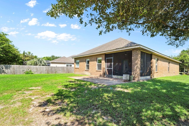 rear view of property featuring brick siding, a patio, and a sunroom