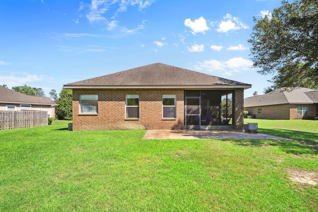 back of house featuring a patio area, a sunroom, roof with shingles, and brick siding