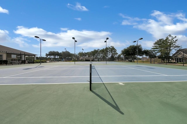 view of tennis court with community basketball court and fence