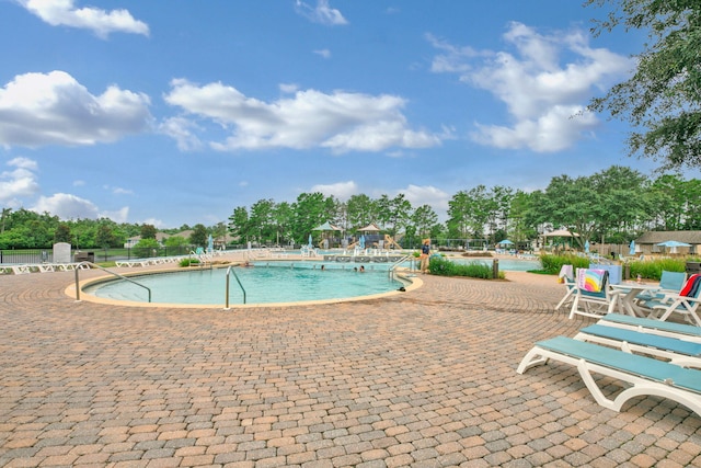 community pool featuring a patio area and fence