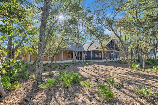 rear view of property featuring a sunroom