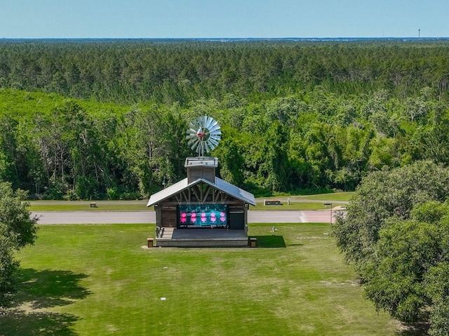 view of property's community with a view of trees and a lawn