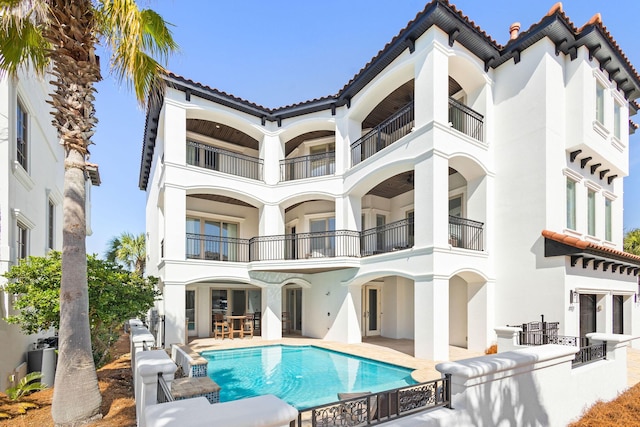 4782 Ocean Blvd, Destin, FL 32541 - rear view of house with a tiled roof, stucco siding, a balcony, and a patio area