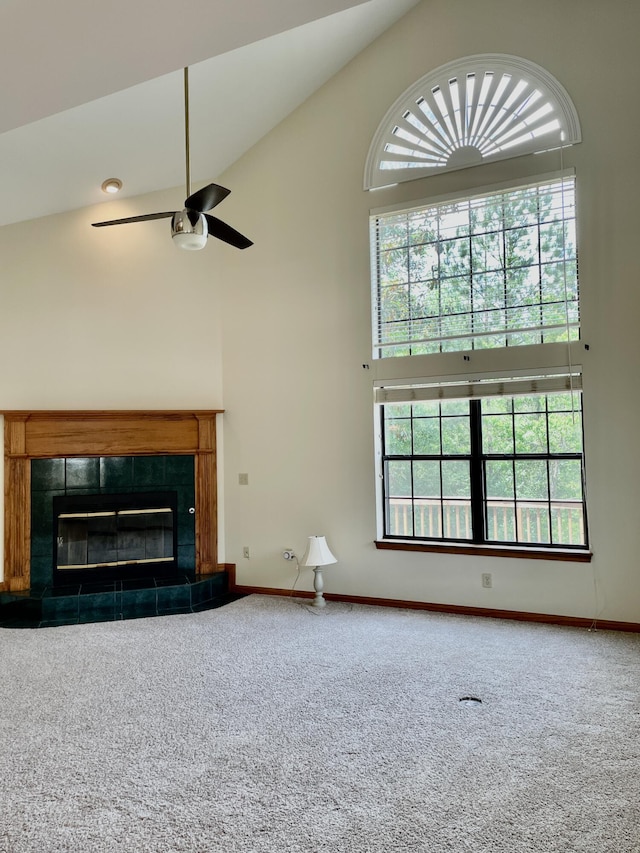 5882 Willow Ln, Crestview, FL 32539 - unfurnished living room featuring high vaulted ceiling, carpet flooring, a tiled fireplace, a ceiling fan, and baseboards