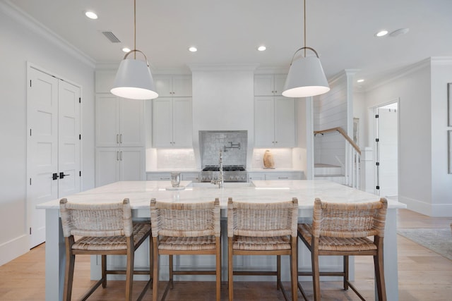 180 Bayou Edge Lndg, Santa Rosa Beach, FL 32459 - kitchen featuring decorative backsplash, recessed lighting, crown molding, light wood finished floors, and white cabinets