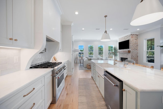 180 Bayou Edge Lndg, Santa Rosa Beach, FL 32459 - kitchen with stainless steel appliances, a sink, open floor plan, white cabinetry, and ornamental molding