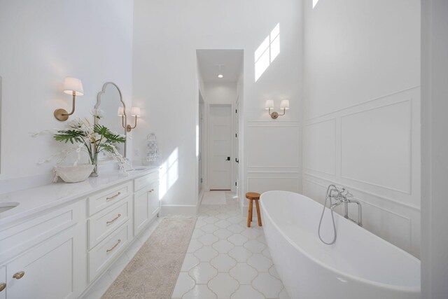 180 Bayou Edge Lndg, Santa Rosa Beach, FL 32459 - bathroom with a decorative wall, a freestanding bath, double vanity, plenty of natural light, and a wainscoted wall