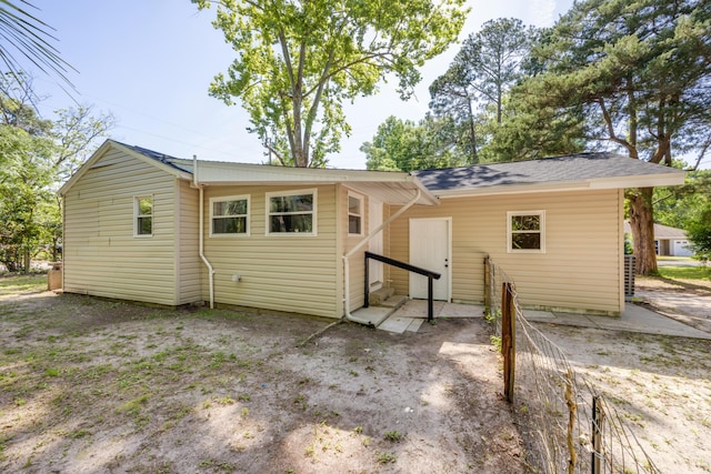 rear view of property with a shingled roof