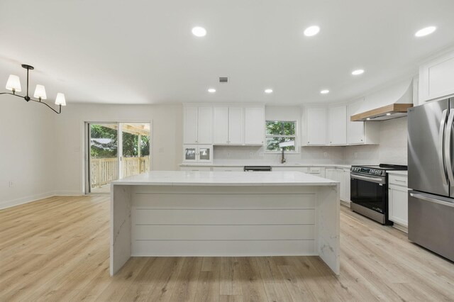 20 NW Higdon Ct, Fort Walton Beach, FL 32547 - kitchen with appliances with stainless steel finishes, premium range hood, a center island, healthy amount of natural light, and recessed lighting