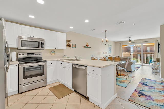 2076 Scenic Gulf Dr Unit 4011, Miramar Beach, FL 32550 - kitchen with stainless steel appliances, a peninsula, a sink, open floor plan, and white cabinetry