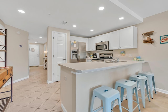 2076 Scenic Gulf Dr Unit 4011, Miramar Beach, FL 32550 - kitchen featuring appliances with stainless steel finishes, a peninsula, a kitchen bar, light countertops, and baseboards