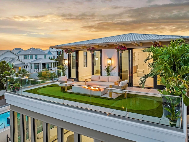 238 Sand Oaks Cir, Santa Rosa Beach, FL 32459 - rear view of property with a balcony, metal roof, and an outdoor living space with a fire pit