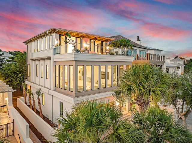 238 Sand Oaks Cir, Santa Rosa Beach, FL 32459 - back of house at dusk featuring a balcony