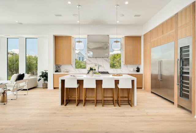 238 Sand Oaks Cir, Santa Rosa Beach, FL 32459 - kitchen with range hood, modern cabinets, light countertops, a center island, and light wood-type flooring