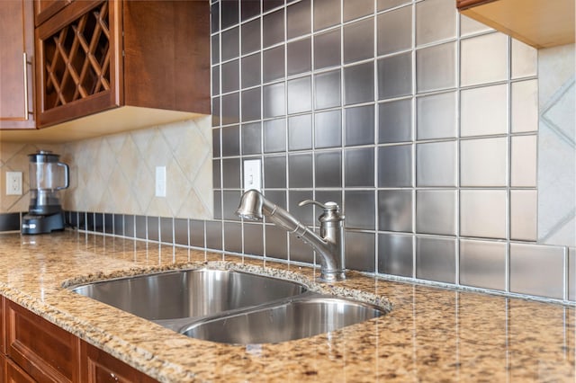 10 Harbor Blvd Unit E409, Destin, FL 32541 - kitchen with a sink, brown cabinets, decorative backsplash, and light stone counters