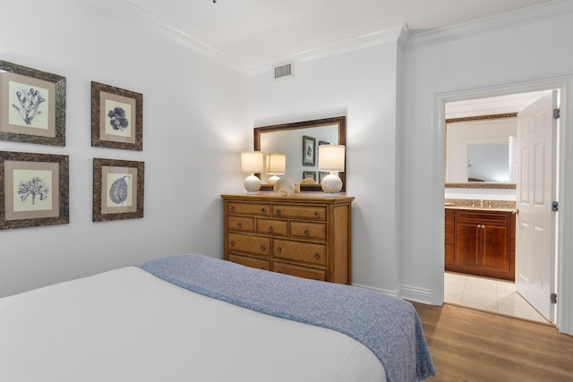 10 Harbor Blvd Unit E409, Destin, FL 32541 - bedroom with crown molding, light wood-style flooring, and ensuite bath