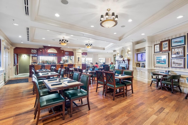 10 Harbor Blvd Unit E409, Destin, FL 32541 - dining area with a tray ceiling, a chandelier, light wood-style floors, ornamental molding, and recessed lighting