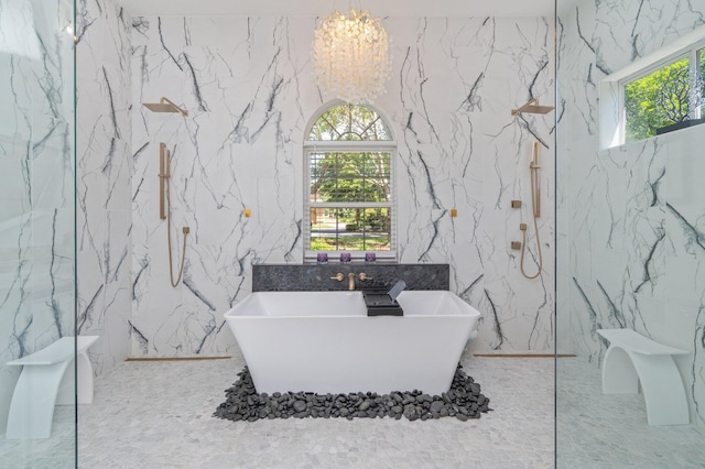 6290 Augusta Cv, Destin, FL 32541 - bathroom with stone wall, a chandelier, a soaking tub, healthy amount of natural light, and tile walls
