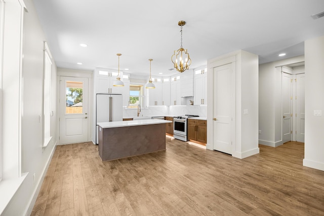 6424 Sunset Ave, Panama City Beach, FL 32408 - kitchen featuring gas range gas stove, a sink, light countertops, a center island, and light wood-style floors