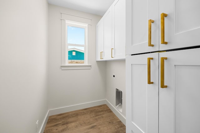 6424 Sunset Ave, Panama City Beach, FL 32408 - washroom featuring cabinet space, hookup for an electric dryer, wood finished floors, and baseboards
