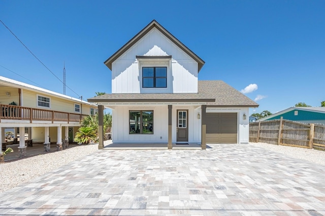 6424 Sunset Ave, Panama City Beach, FL 32408 - modern farmhouse featuring a porch, fence, decorative driveway, board and batten siding, and a garage