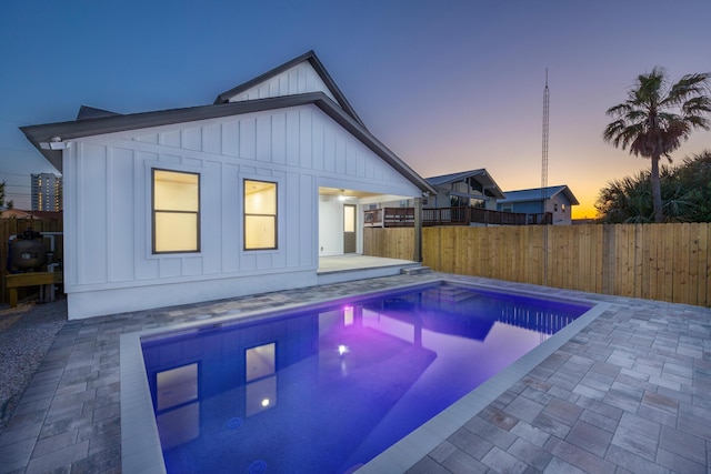 6424 Sunset Ave, Panama City Beach, FL 32408 - pool at dusk with fence, a patio, and an outbuilding