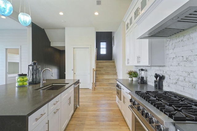 336 S Holiday Rd, Destin, FL 32550 - kitchen featuring wall chimney range hood, appliances with stainless steel finishes, a sink, dark countertops, and backsplash